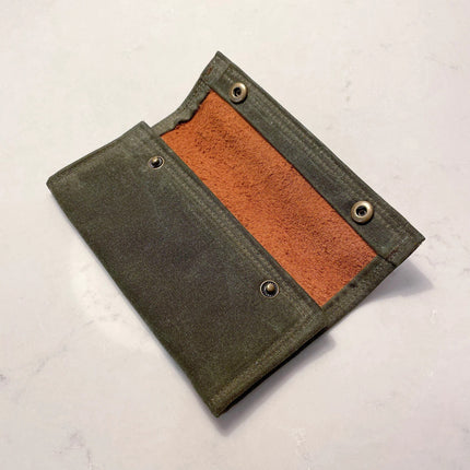 the waxed canvas fly fishing wallet unsnapped to show partial interior