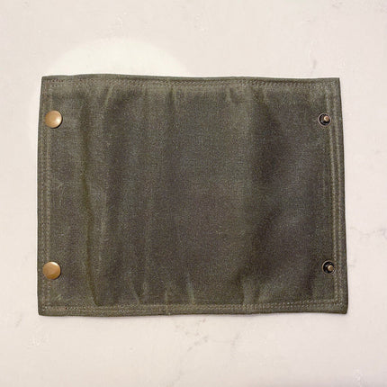 the fly fishing wallet unfolded face down showing the entire waxed canvas surface