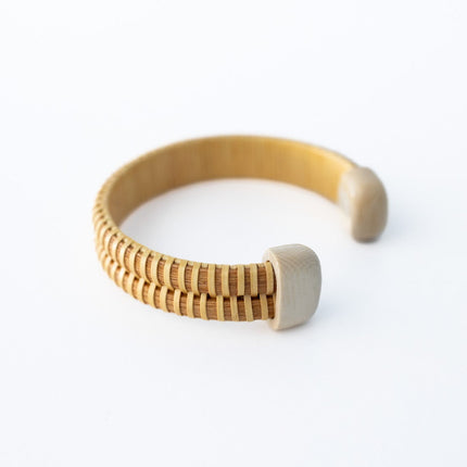 Wooden bracelet with bone white end caps on a white background