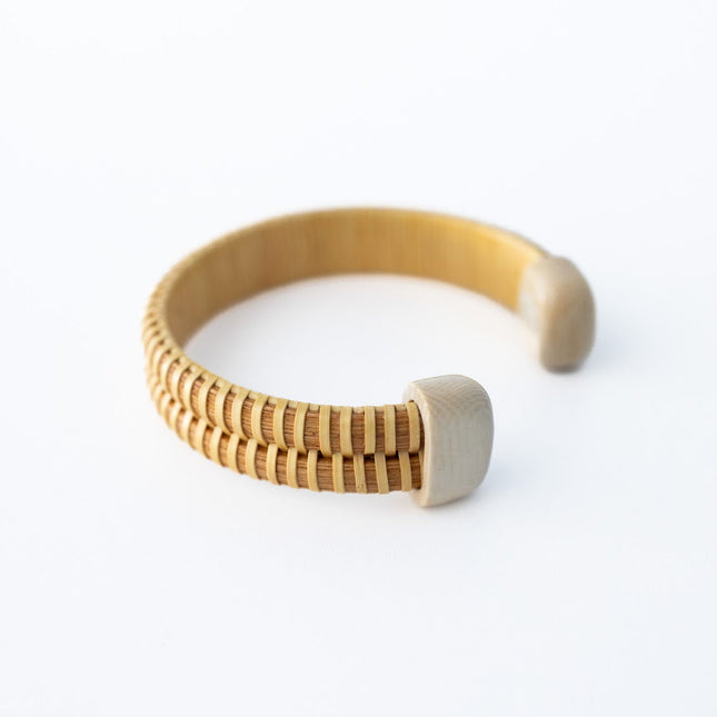 Wooden bracelet with bone white end caps on a white background