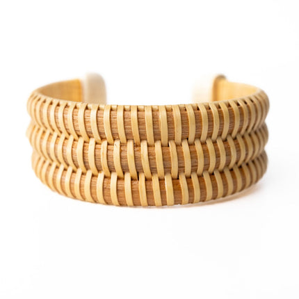 wide, woven rattan cuff on a white background