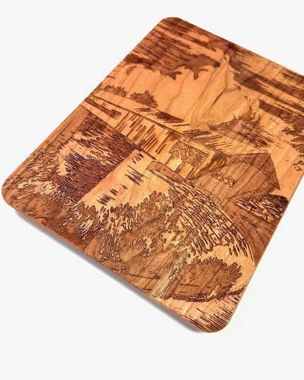 Wooden cutting board with engraved design on a white background