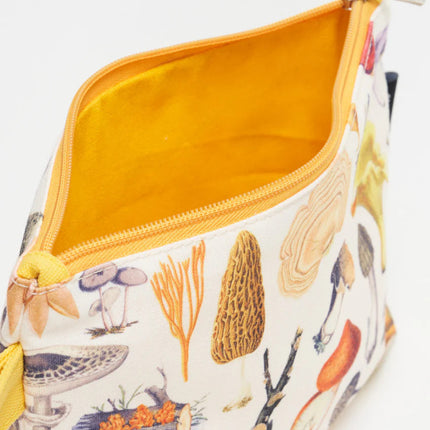 a close up of the woodland mushrooms zipper pouch showing the pouch unzipped revealing the solid goldenrod yellow lining