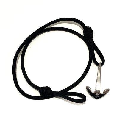 a black cord wrap bracelet with silver anchor charm unwrapped in a loose circle showing the nearly unwrapped length of the bracelet
