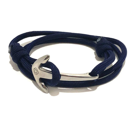 a navy blue wrap bracelet made of cord that is held in place with a silver anchor charm
