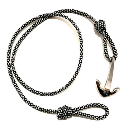 a black with white diamond pattern cord wrap bracelet with silver anchor charm unwrapped in a loose circle showing the nearly unwrapped length of the bracelet