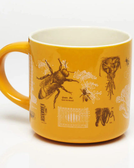 a yellow coffee mug with vintage illustrations honey bees