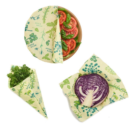 3 pieces of bees wrap with herb garden print in use - one on a salad bowl, one wrapping herbs, a third wrapped around red cabbage