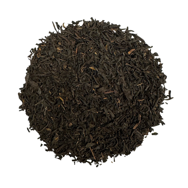Close-up of dark brown tea leaves on a white background