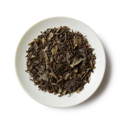 a small white round dish containing a mound of bold coast breakfast loose leaf tea showing the black tea and kelp ingredients