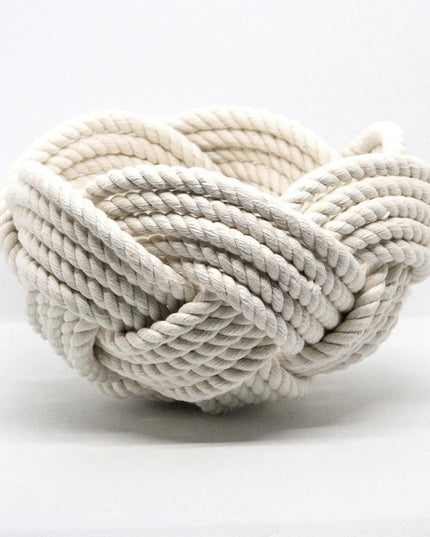 a hand woven cotton rope bowl in white against a white background