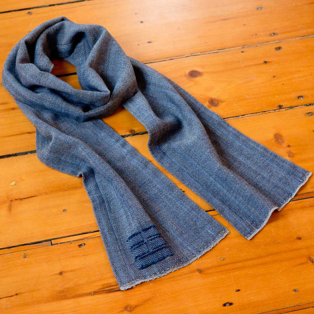 The Camden scarf in Indigo on a wooden surface