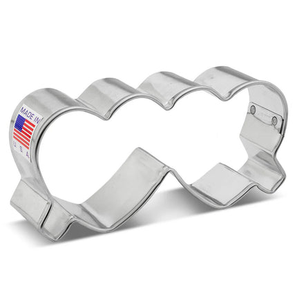a silver, tin cookie cutter in the shape of folded heart-shaped glasses