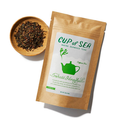 a kraft tea package with a white and green label that reads "Cup of Sea - Maine Seaweed Teas - Emerald Honeybush" with a graphic of a solid green tea kettle with seaweed shaped steam rising out of the spout next to a small round bowl filled with loose leaf tea