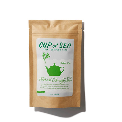 a kraft tea package with a white and green label that reads "Cup of Sea - Maine Seaweed Teas - Emerald Honeybush" with a graphic of a solid green tea kettle with seaweed shaped steam rising out of the spout
