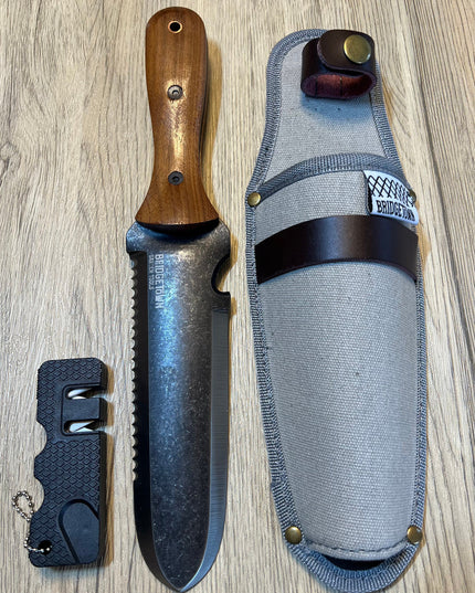Essential Hori Hori knife shown side by side with its sheath and sharpener - side one of knife