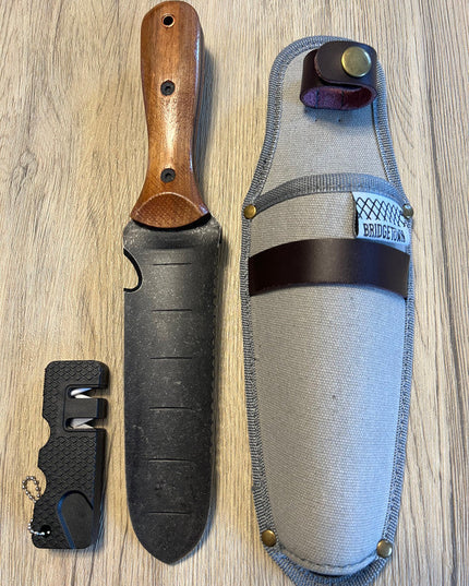 Essential Hori Hori knife shown side by side with its sheath and sharpener - side two of knife