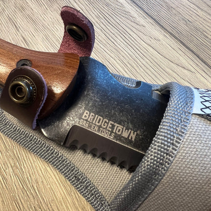 Close up image of Essential Hori Hori knife handle and blade partially in the sheath