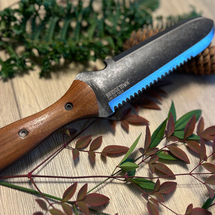 Essential Hori Hori knife on a table with freshly cut greens