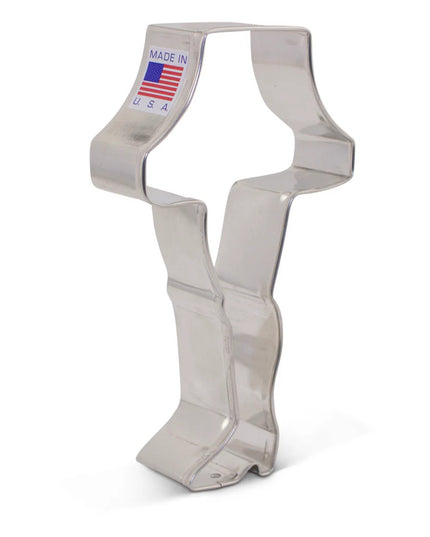 a tin cookie cutter in the shape of a leg in high heels topped with a lampshade