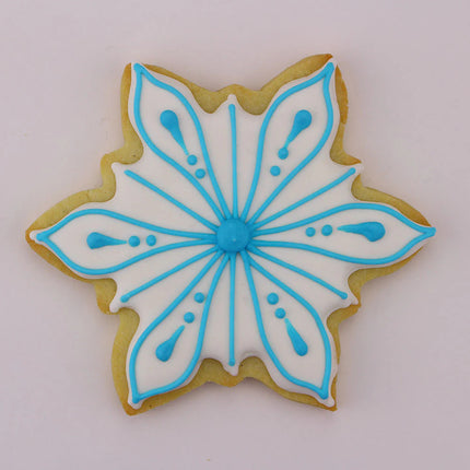 Icy Snowflake shaped cookie with white icing with blue piped snowflake detailed decor
