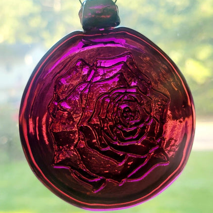 Purple glass suncatcher with a rose design.