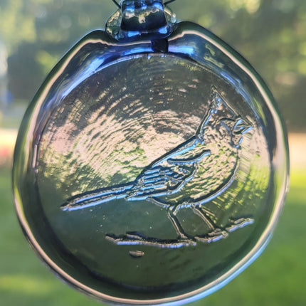 Light purple glass suncatcher with a folk art cardinal design.
