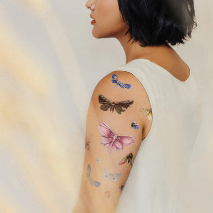 a rear side angle of a model's arm with the floraflies tattoos applied all over her upper arm