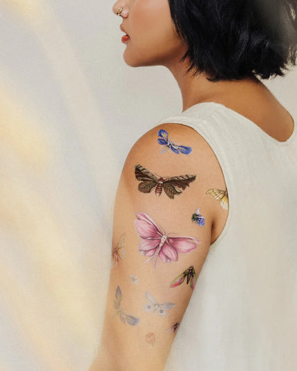 a rear side angle of a model's arm with the floraflies tattoos applied all over her upper arm