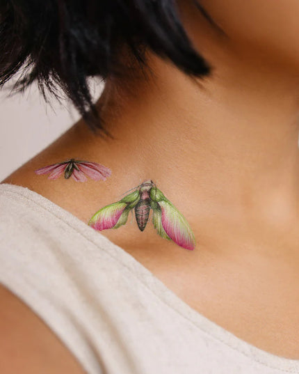 close up of a model's neck and collarbone showing two tattoos applied just above her collarbone