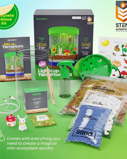 The light up terrarium package and full contents showing the container, light up lid, charging cable, sand, rocks, soil, decorative figures, stickers, spray bottle and tools
