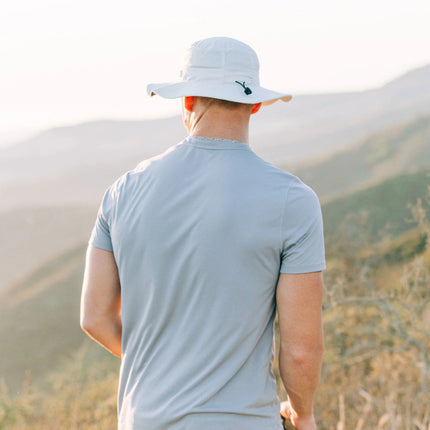 a model wearing the venture sun hat on a hill side with their back to the viewer