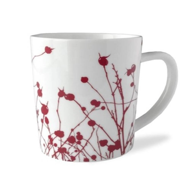 a white mug with red silhouette images of winterberries against a white background